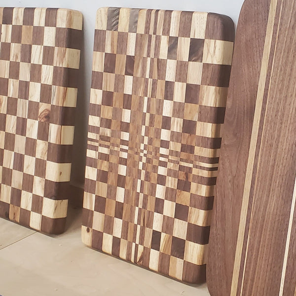 Set of wooden cutting boards with different patterns on a light wood floor.